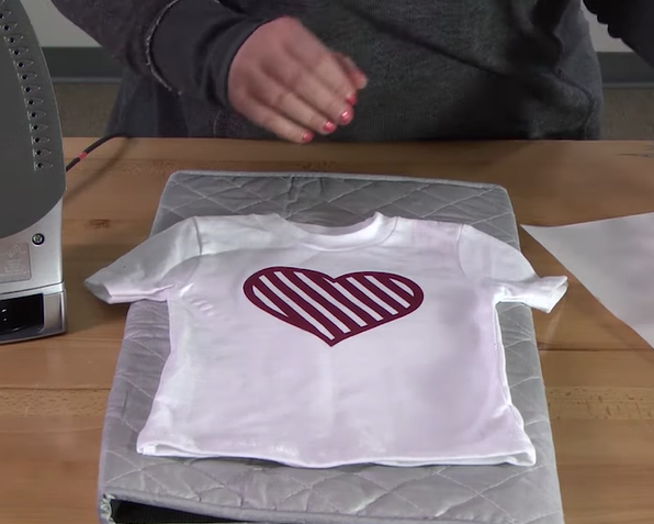 This is a cover image showing vinyl being heat-pressed with an iron.