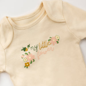 Beige baby onesie with floral design and text on a white background