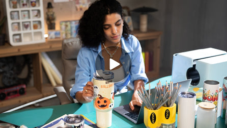 Woman at a desk with a mug and stationery items, blurred background