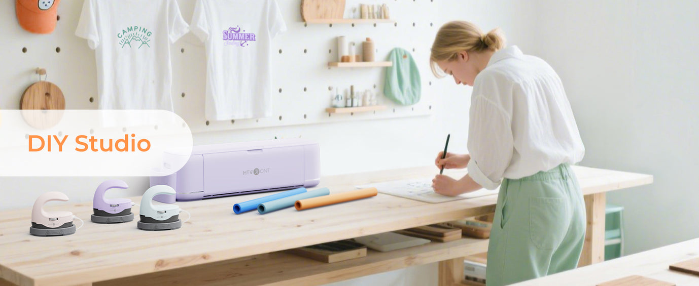 Person working at a table with Cricut machines and supplies in a DIY studio setting.